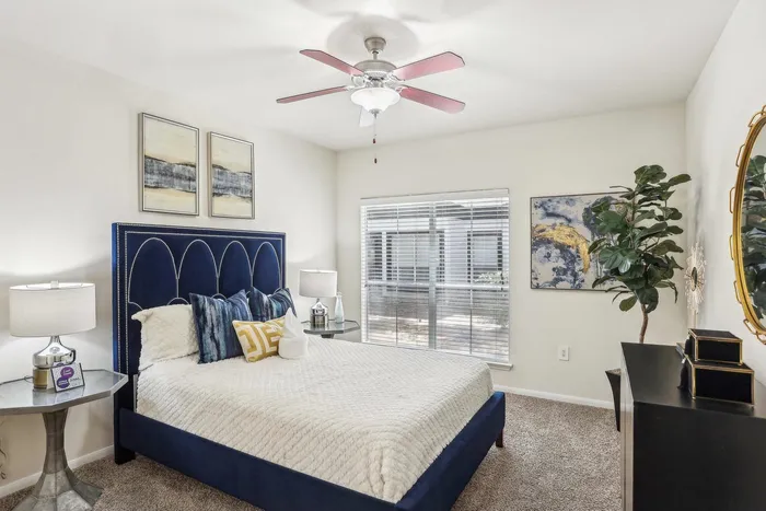 spacious bedroom with ceiling fan and carpet