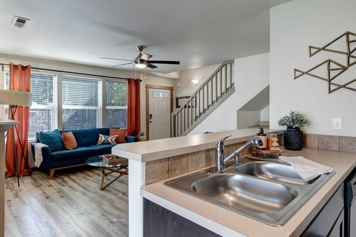 Kitchen with double sink, dark cabinets, and sliding glass doors leading to a patio at Navigator Villas in Pasco, WA.