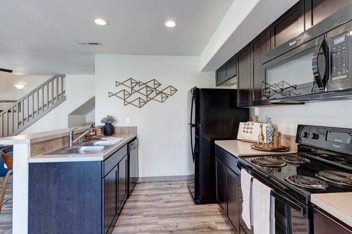 Sleek kitchen with dark cabinets, modern appliances, and breakfast bar seating at Navigator Villas in Pasco, WA.