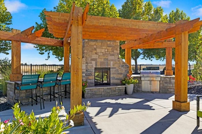 Outdoor patio with stone fireplace, grill, and cozy seating at Navigator Villas in Pasco, WA.