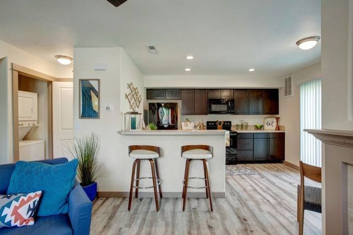 Open-concept kitchen and living area with wood-style flooring at Navigator Villas in Pasco, WA.