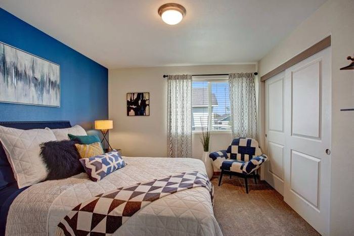 Cozy bedroom with blue accent wall and natural light at Navigator Villas in Pasco, WA.