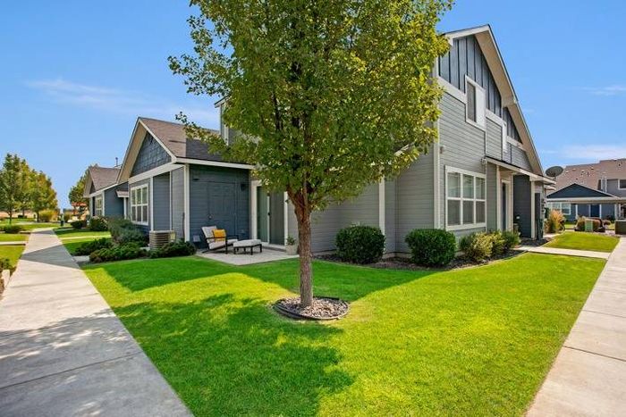 Well-maintained townhome exterior with a tree-lined walkway at Navigator Villas in Pasco, WA.