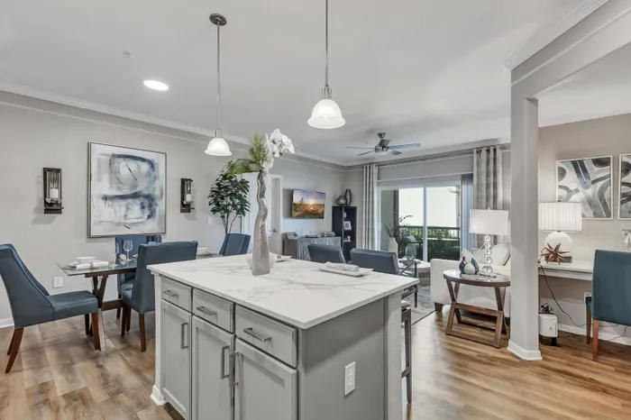 Open-concept living and dining area with modern kitchen at Amalfi at Tuscan Lakes in League City, TX.