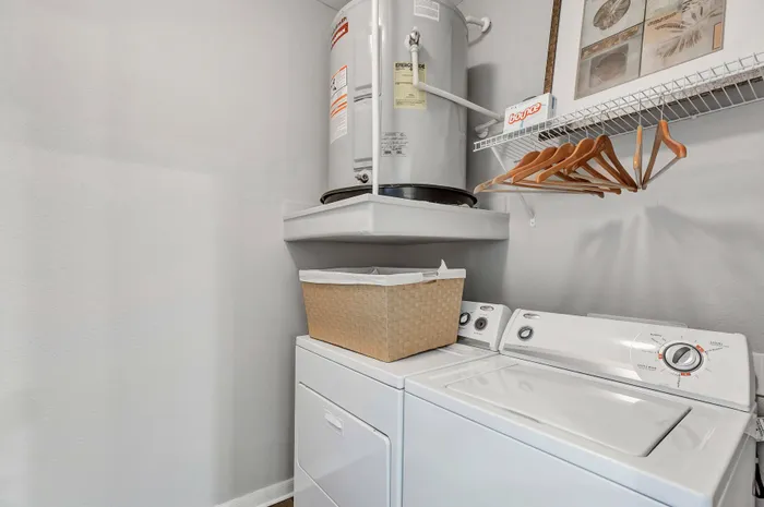 In-unit laundry room with washer, dryer, and convenient shelving at Amalfi at Tuscan Lakes in League City, TX.