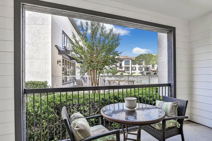 Private balcony with patio seating overlooking the pool area at Amalfi at Tuscan Lakes in League City, TX.