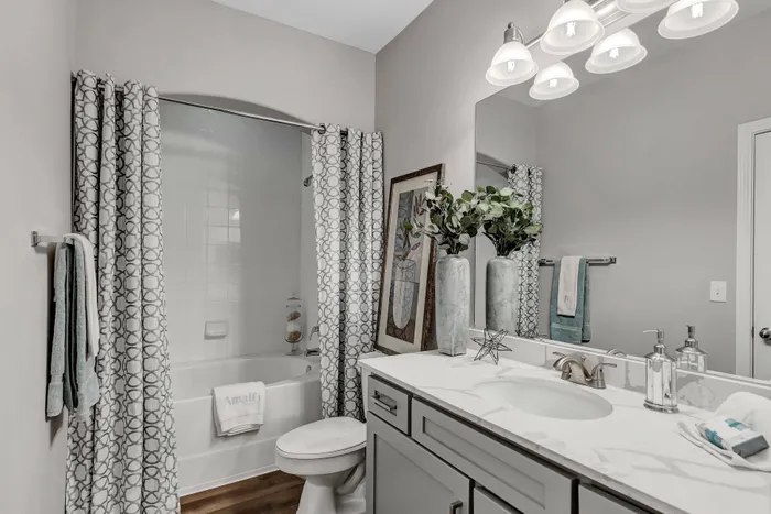 Bathroom with modern vanity, stylish décor, and shower-tub combo at Amalfi at Tuscan Lakes in League City, TX.