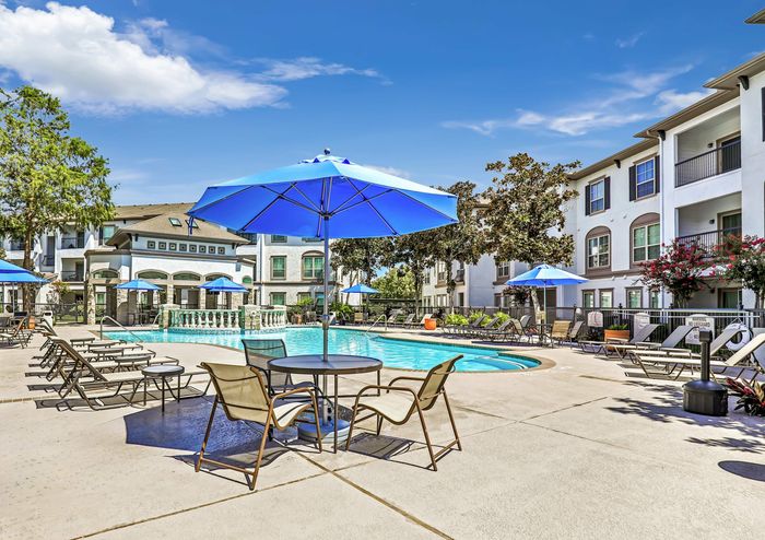 sparkling swimming pool with shaded poolside seating