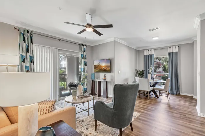 large room with furniture, light walls, and wall-to-wall hardwood flooring