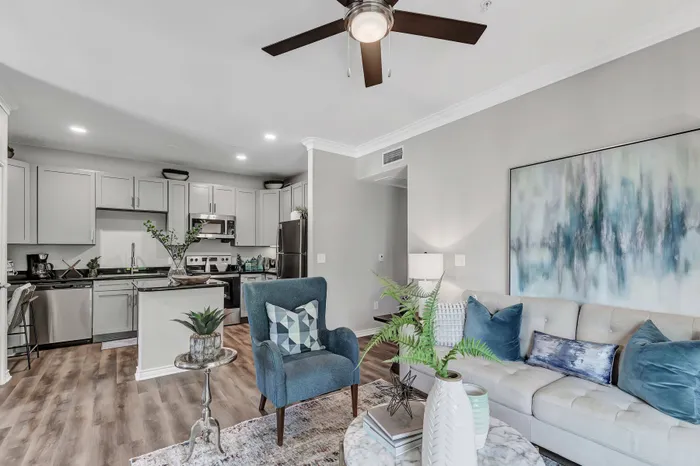large room with furniture, light walls, and wall-to-wall hardwood flooring