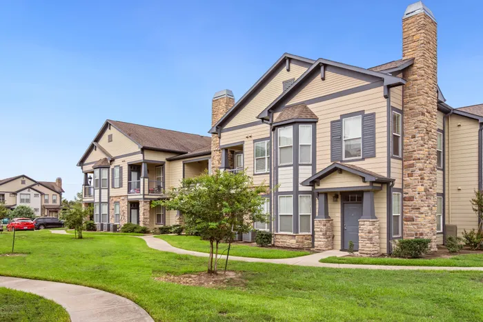 Building exterior view of Katy Ranch Apartments in Katy, TX, showcasing modern architecture and lush landscaping.