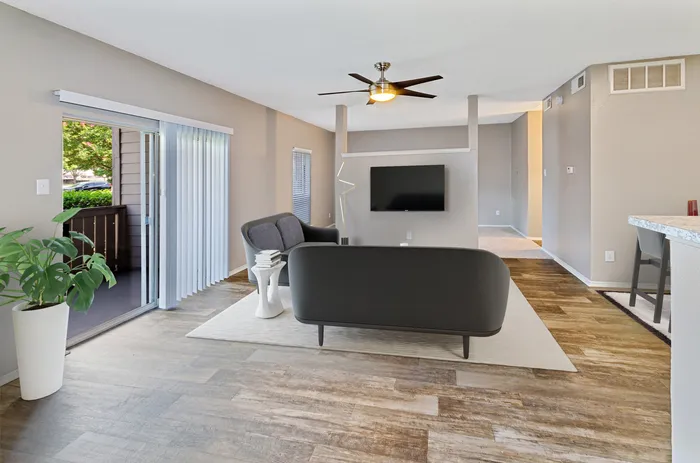 Bright and airy living room with sliding glass doors leading to a private balcony in Plano, TX.