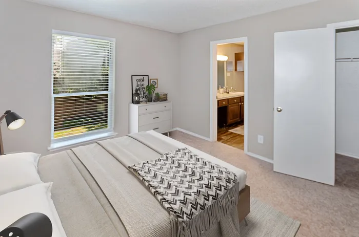 Stylish bedroom with soft natural light, cozy decor, and an en-suite bathroom in Plano, TX.