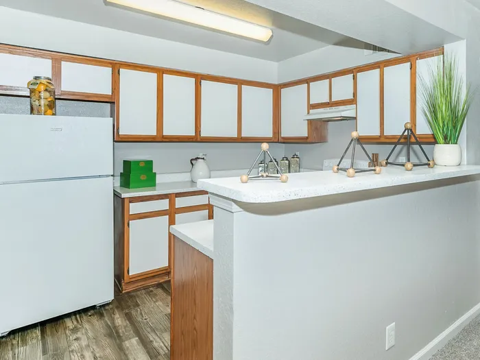 kitchen with white cabinets, a white refrigerator, and a bar