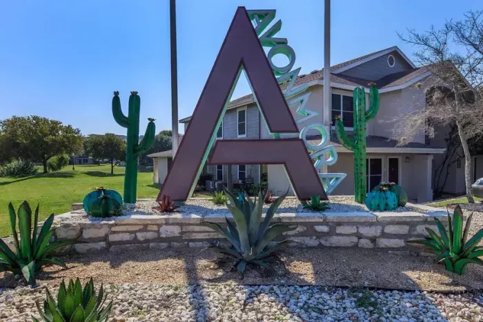 Modern monument sign featuring desert landscaping and the 'A' logo at Avonmora Apartments in Austin, TX.