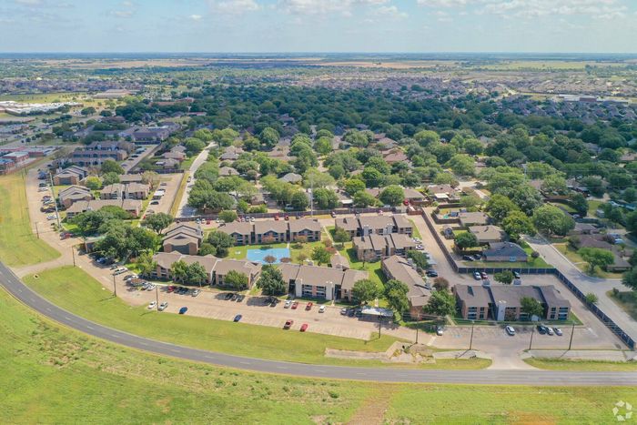 Aerial view of Bridgepoint Apartments showcasing spacious grounds, greenery, and pool amenities in Waxahachie, TX.