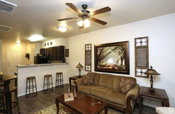 Stylish open-concept living room with comfortable seating and warm decor at Arroyo Seco Villas in San Antonio, TX.