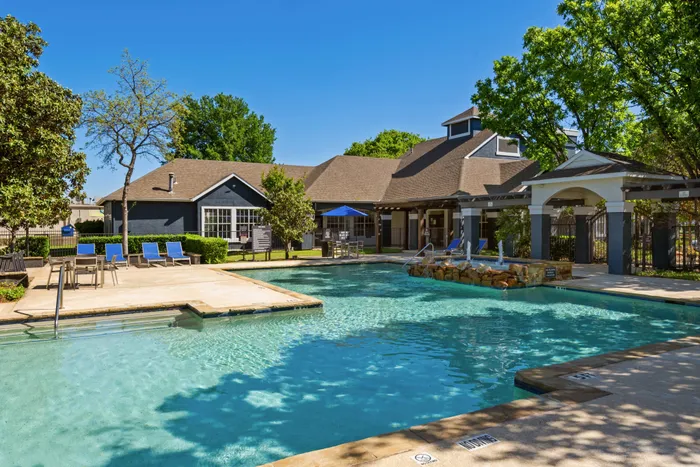 tree-lined pool with large walkway and shaded seating