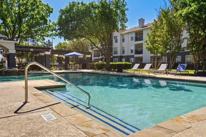 tree-lined pool with large walkway and shaded seating