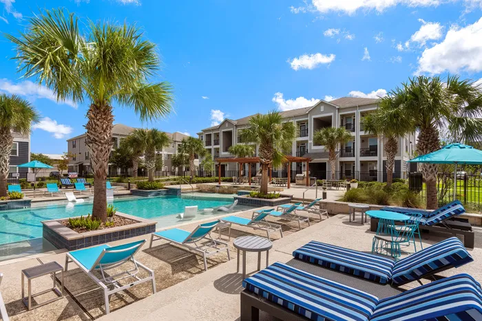 Resort-style swimming pool with in-pool loungers at The Retreat in Corpus Christi, TX