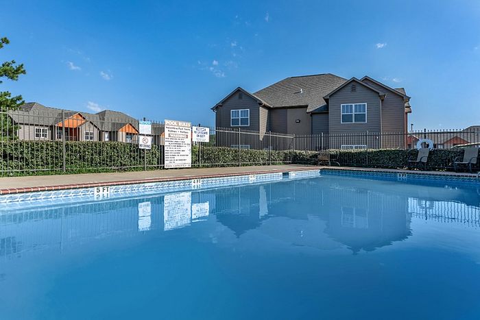 an apartment building overlooking a large swimming pool with clean and clear water