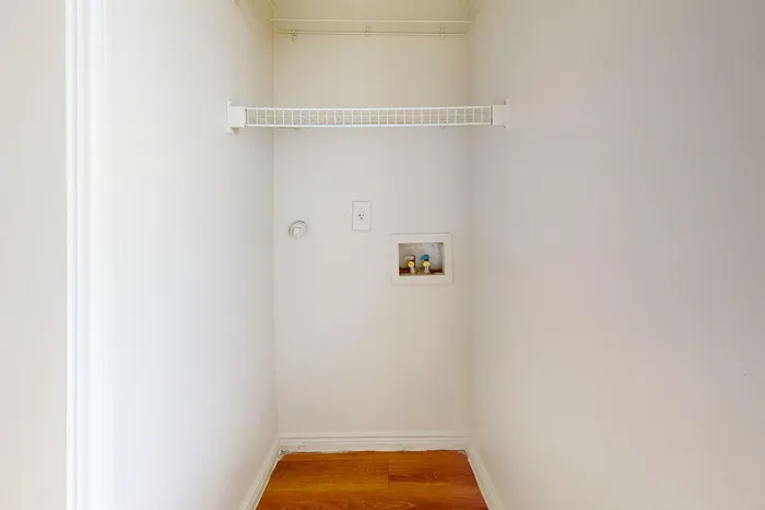 Spacious utility area with hookups and shelving for laundry appliances at Willowbend Apartments in San Antonio, TX.