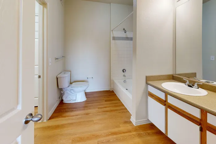 Bathroom featuring a clean vanity, large mirror, and bright lighting at Willowbend Apartments in San Antonio, TX.