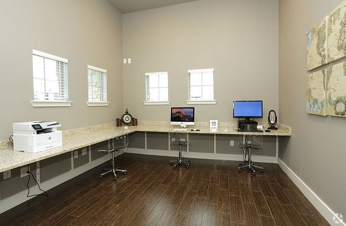 Fully equipped business center with modern computers, printer, and granite countertops at Arroyo Seco Villas in San Antonio, TX.