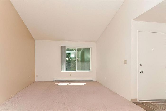 Bright and spacious living room with large windows and modern flooring at Cottage Bay Apartment Homes in Bremerton, WA