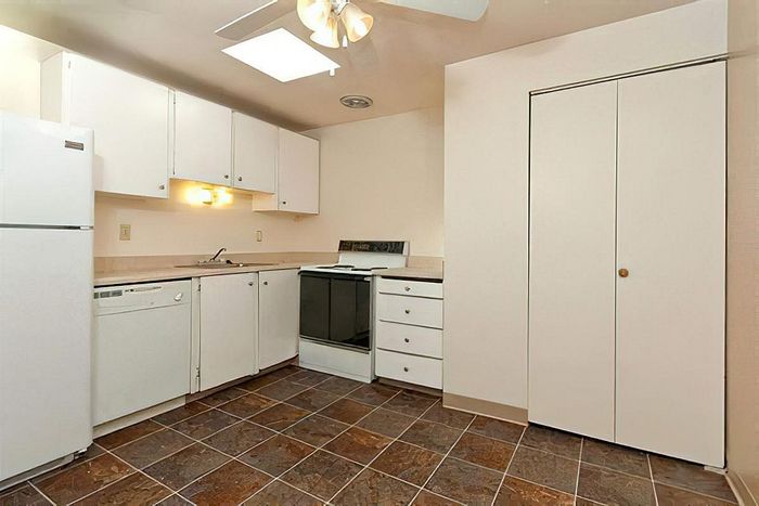 Contemporary kitchen with stainless steel appliances and granite countertops at Cottage Bay Apartment Homes in Bremerton, WA