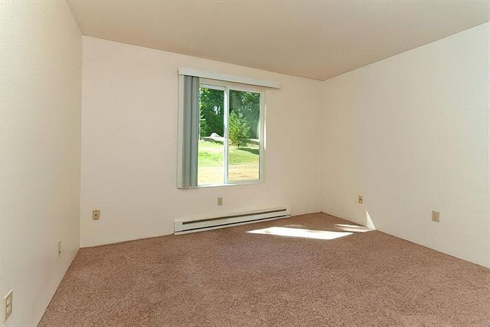 Bright and spacious bedroom with large windows at Cottage Bay Apartments, Bremerton, WA