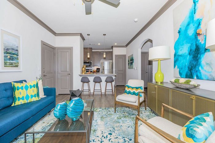 Open-concept apartment interior with modern kitchen, stylish furniture, and vibrant decor at Cityscape Apartments in Houston, TX.