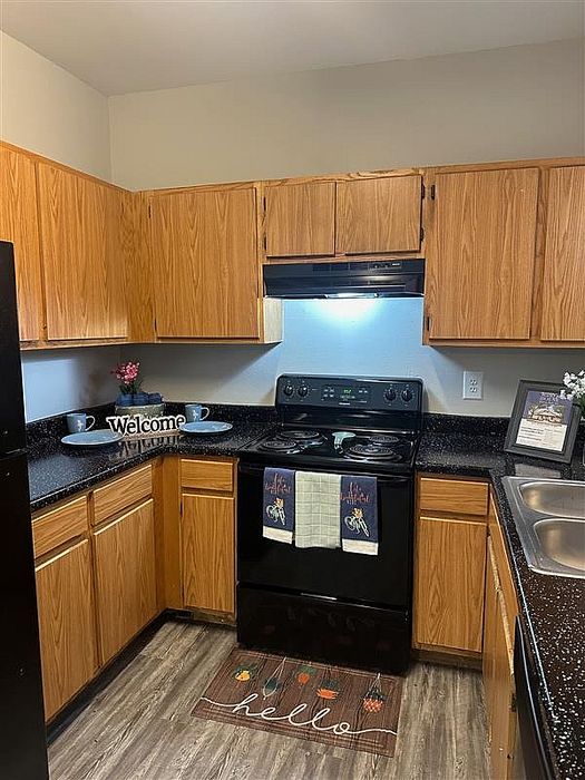Kitchen with close-up on the black stove and welcoming decor at Granada Place Apartments in Uvalde, TX.