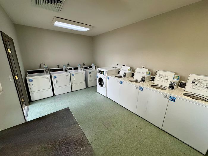 Clean and spacious laundry room with modern machines at Granada Place Apartments in Uvalde, TX.