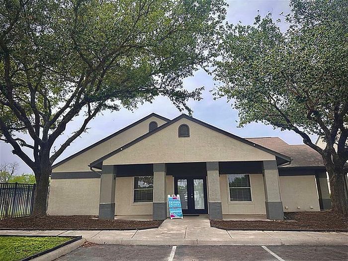 Modern leasing office with shaded entrance and tree-lined surroundings at Granada Place Apartments in Uvalde, TX.
