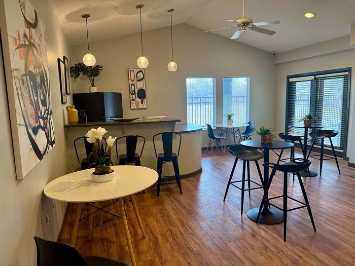 Stylish community lounge with modern decor, seating, and a kitchenette at Granada Place Apartments in Uvalde, TX.