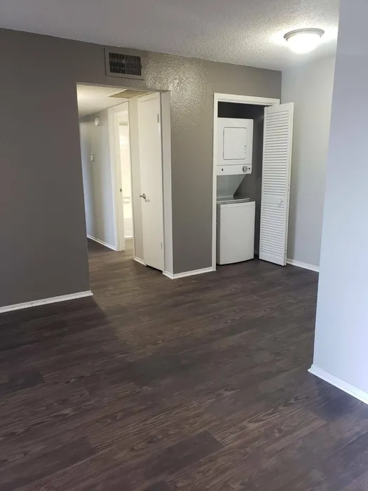 spacious living with wood style flooring and stacked washer dryer