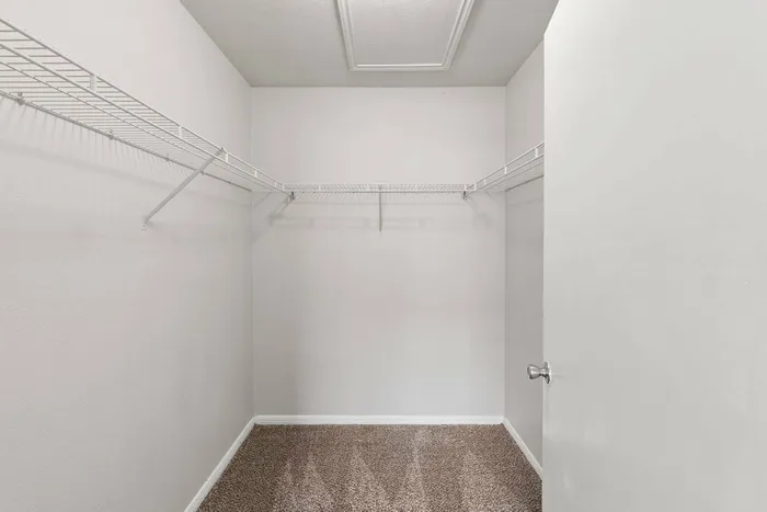 Walk-in closet with ample storage space at Crescent Village Apartments, Elgin, TX.