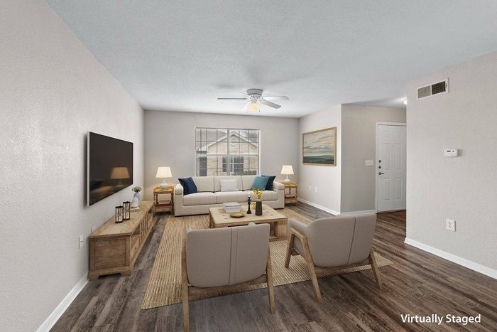 Open living space with built-in shelving, natural light, and wood-style flooring at Crescent Village in Elgin, TX.