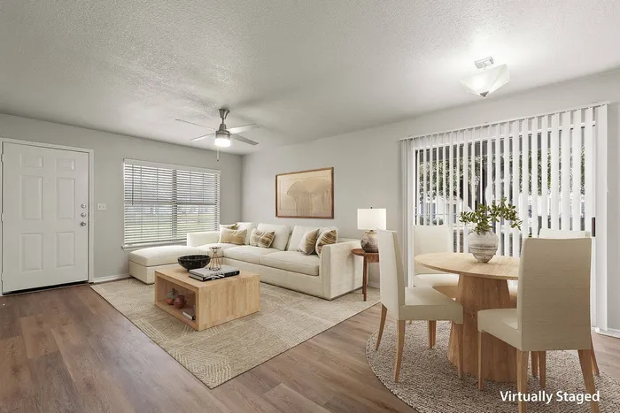 Bright and stylish living room with connected dining area, featuring modern decor and open-concept design at Avonmora Apartments in Austin, TX
