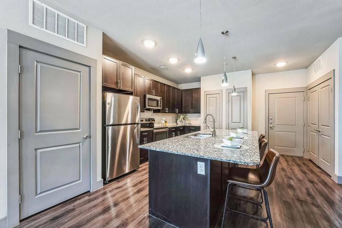 State-of-the-art kitchen with a large island and spacious open living room at Discovery Park in Denton, Texas.