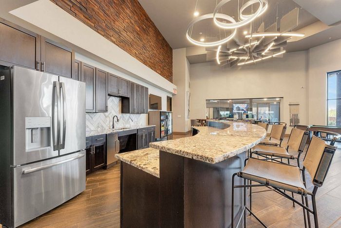 Community lounge with modern fireplace, velvet seating, and artistic decor at Discovery Park, Denton, TX, offering luxury amenities.