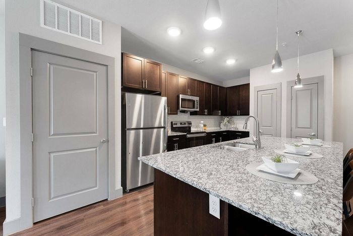 Wide kitchen view with dark cabinets and breakfast bar
