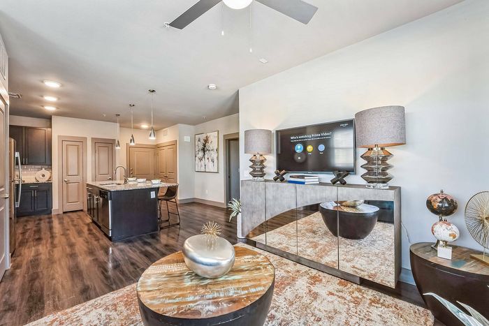 Living and kitchen view from dining area with granite countertop and decorative lamps