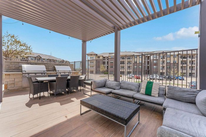 Outdoor grilling and lounge area with pergola at Discovery Park Apartments in Denton, TX