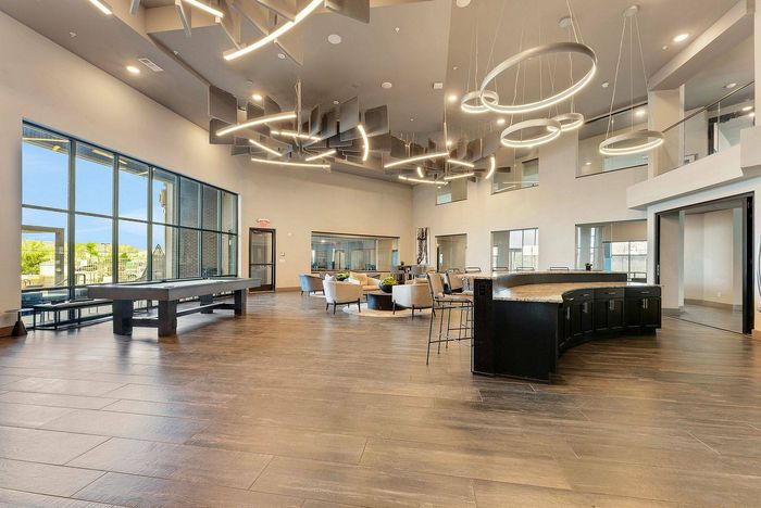 Game lounge at Discovery Park Apartments with pool table, bar seating, and lounge furniture