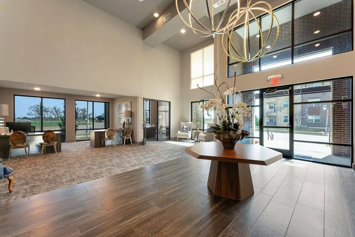 Leasing office interior with modern wood furniture and large windows at Discovery Park Apartments in Denton, TX