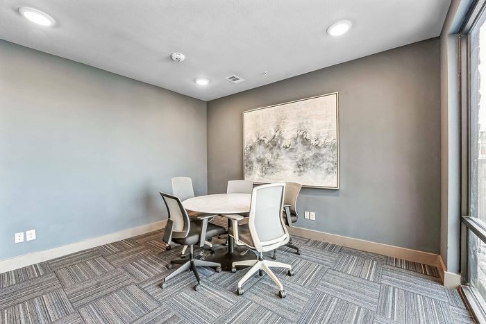 Private conference room with round table and five modern chairs at Discovery Park Apartments in Denton, TX