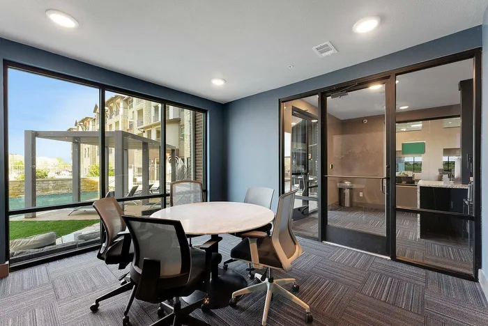 Poolside conference room with round table and chairs at Discovery Park Apartments in Denton, TX
