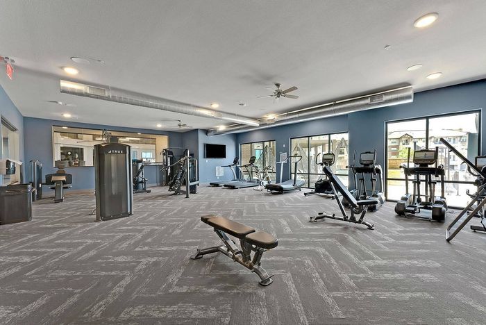 Wide-angle view of Discovery Park&rsquo;s gym with free weights and machines